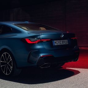 Вид модели BMW 4 серии Coupe G22 2020 года сзади с поворотом в три четверти, патрубки системы выпуска BMW 4 серии Coupe G22 2020 года, цвет «Синий Арктик Рэйс» металлик, вид сзади с поворотом в три четверти, патрубки системы выпуска