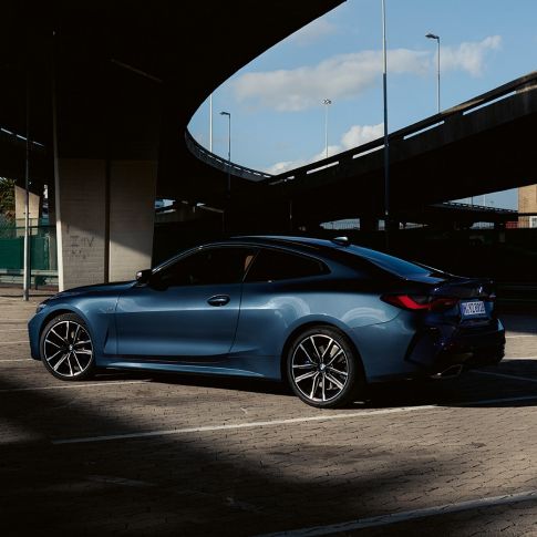 Модель BMW M440i xDrive Coupe G22 (2020), вид сзади с поворотом в три четверти Модель рядом с BMW M440i xDrive Coupe G22 (2020), Синий Арктик Рэйс металлик вид сзади с поворотом в три четверти