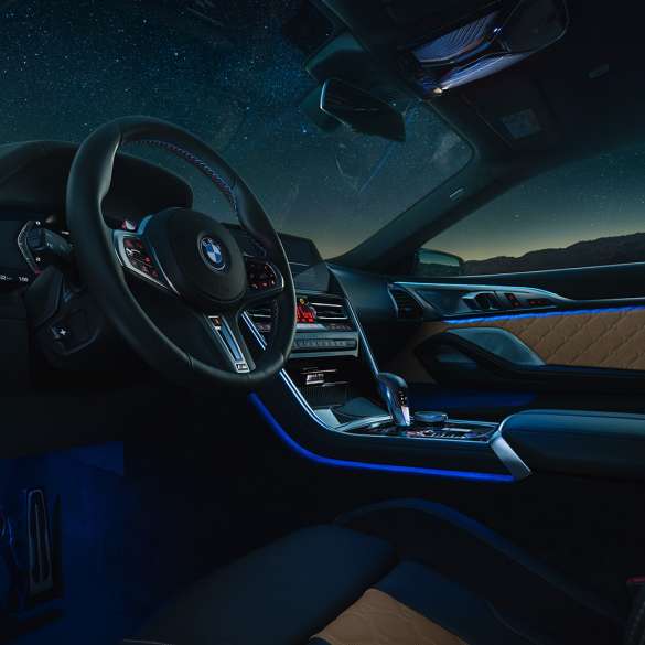 BMW M8 Competition Coupé, кабина. BMW M8 Competition Coupé, кабина ночью с кожаным рулевым колесом M и синим фоновым освещением.