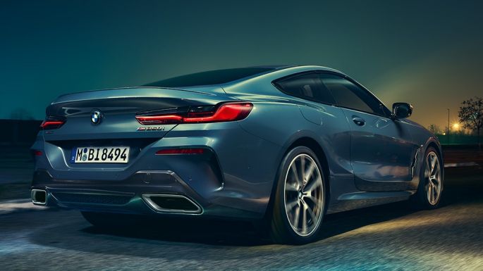 BMW M850i xDrive Coupé, вид сзади. BMW M850i xDrive Coupé в Barcelona Blue металлик, вид сзади, езда ночью.