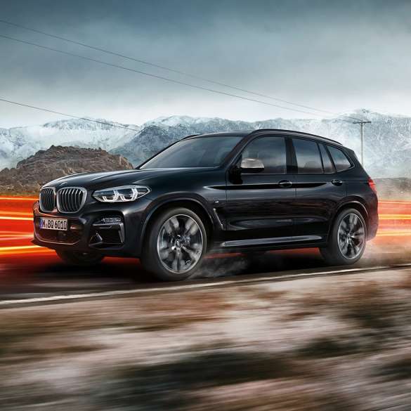 BMW X3 M40i и BMW X3 M40d, вид сбоку. BMW X3 M40i и BMW X3 M40d в Black Sapphire металлик, за рулем, экстерьер, вид сбоку перед горным пейзажем со световыми полосками.