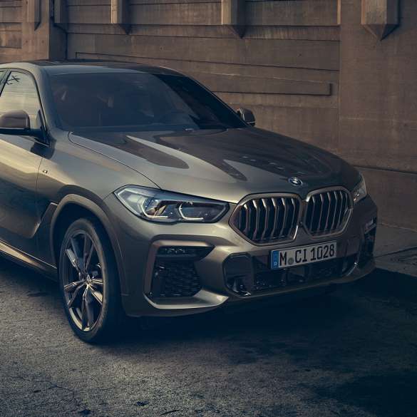 BMW X6 M50i с 8-цилиндровым бензиновым двигателем M TwinPower Turbo BMW X6 M50i G06 с 8-цилиндровым бензиновым двигателем M TwinPower Turbo в цвете Manhattan (металлик), вид сбоку с поворотом в три четверти