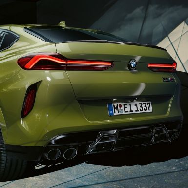 BMW X6 M Competition, вид сзади с поворотом в три четверти BMW X6 M Competition F96 со спортивной системой выпуска, специальное лакокрасочное покрытие зеленого цвета Urban из линейки BMW Individual, вид сзади с поворотом в три четверти