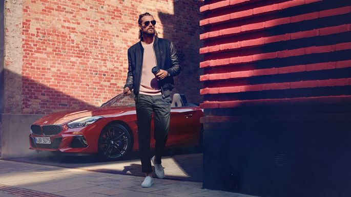 BMW Z4 Родстер в переулке Мужчина в переулке перед BMW Z4 Roadster