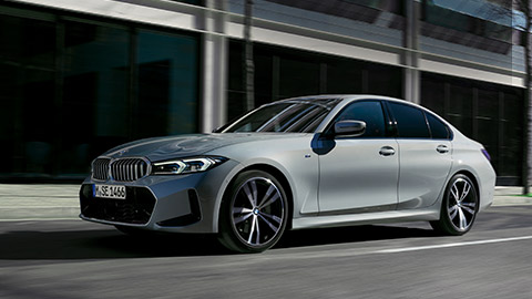 Седан BMW 3 серии LCI G20 в цвете Brooklyn Grey, вид сбоку на фоне стены