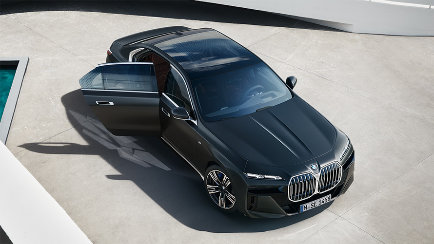 BMW 7 серии Седан G70 ICE 740i с пакетом M Sport в цвете Frozen Deep grey metallic, вид с высоты птичьего полета с открытой пассажирской дверью