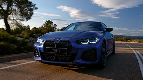 BMW i Серии BMW i4 M50 вид спереди с поворотом в три четверти, в движении по улице