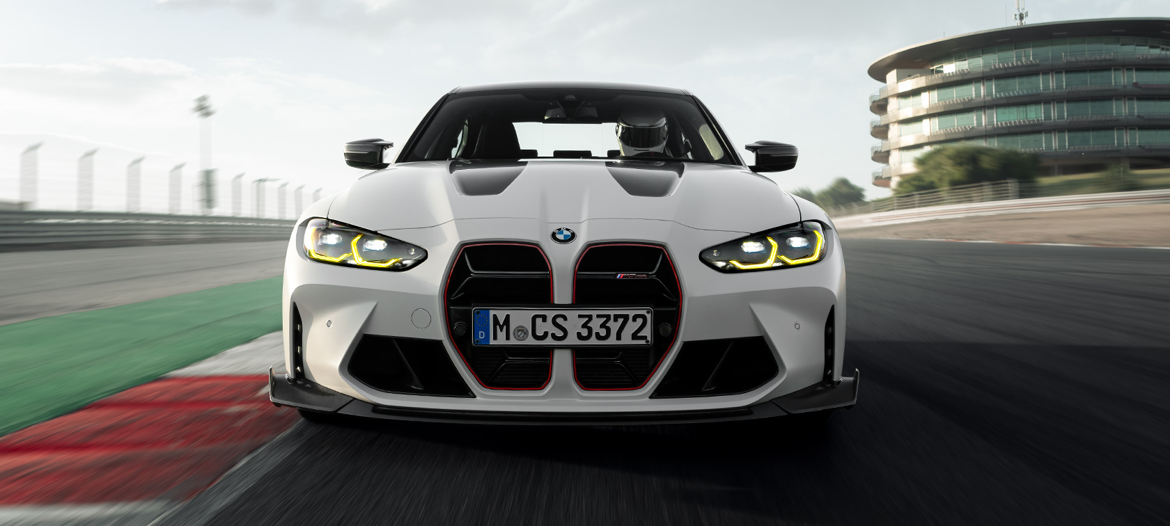 Аксессуары BMW M Performance BMW M3 CS G80 BMW M3 CS G80, аксессуары BMW M Performance, вид спереди в три четверти в движении по гоночной трассе