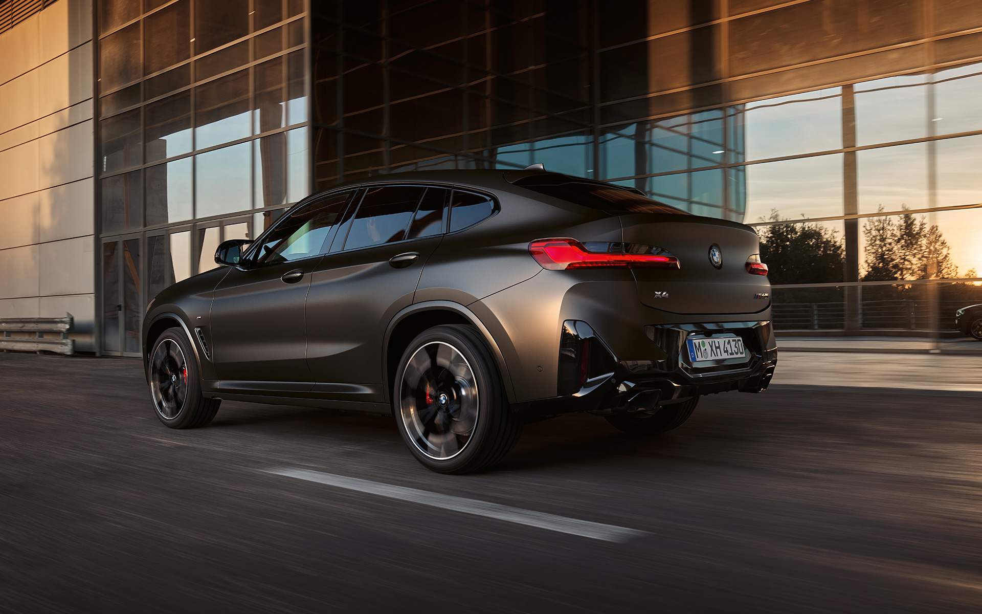 BMW X4 M40i G02 LCI 2021 Facelift, вид сзади в три четверти перед стеклянным фасадом