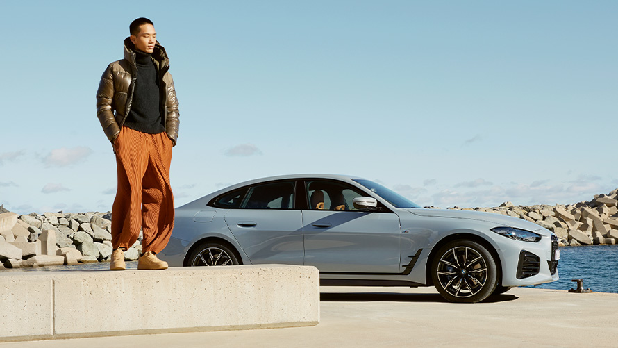 BMW Service Inclusive BMW Service Inclusive BMW G26 Мужчина стоит на каменной плите на фоне автомобиля BMW