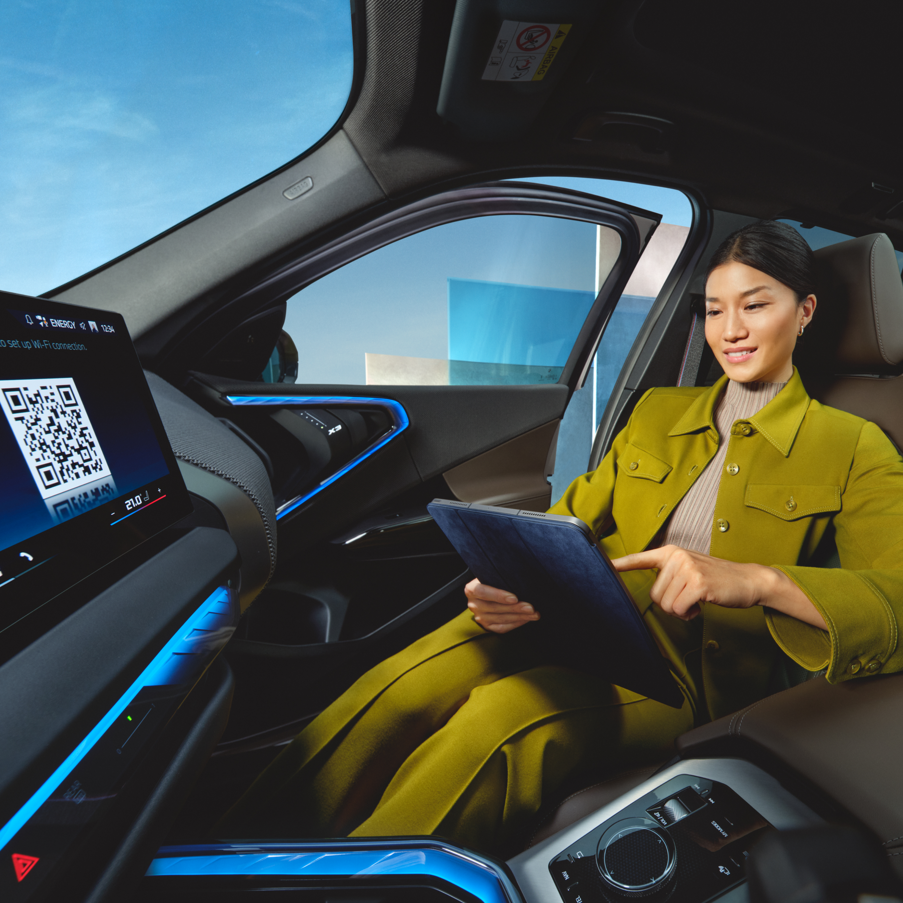 Человек использует планшет, сидя в BMW